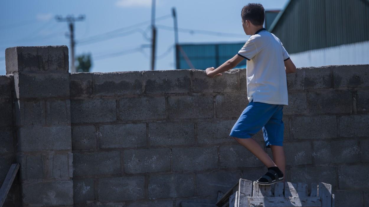 A 15-year-old boy left behind by migrating parents and living alone in south Kyrgyzstan.